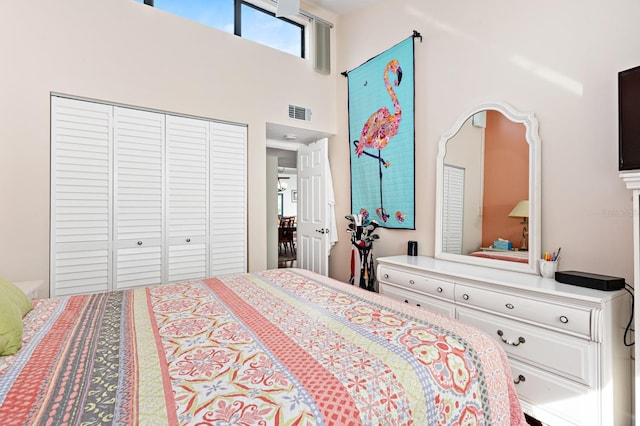 bedroom featuring a towering ceiling and a closet