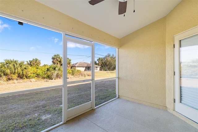 unfurnished sunroom with vaulted ceiling and ceiling fan