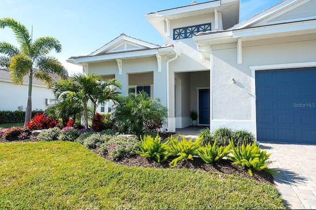 doorway to property featuring a garage and a yard