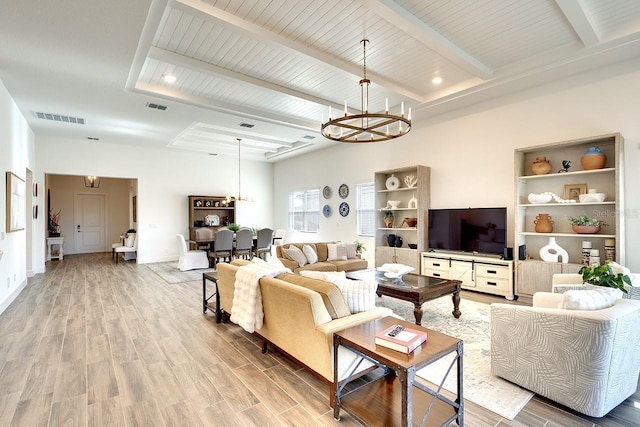 living room with hardwood / wood-style flooring, a notable chandelier, and beamed ceiling