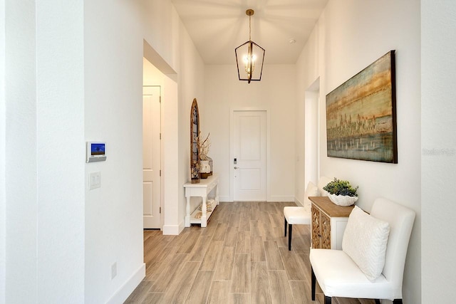 hallway featuring light hardwood / wood-style floors and a chandelier