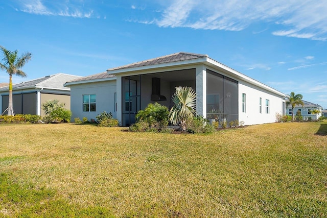 back of property featuring a sunroom and a yard