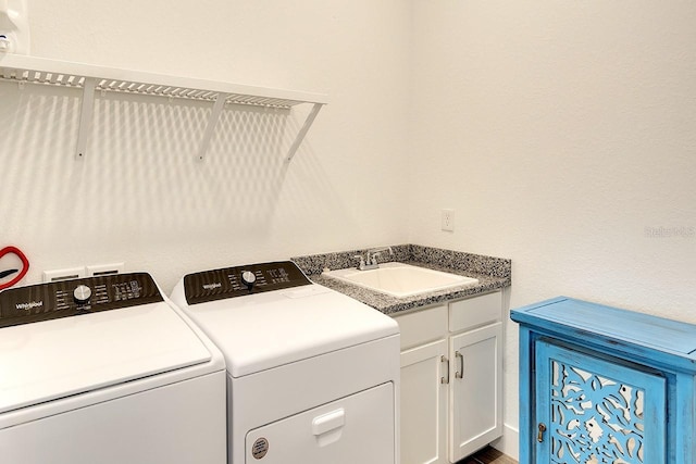 washroom with cabinets, washer and clothes dryer, and sink