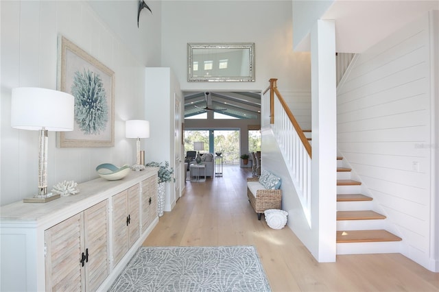 interior space with a towering ceiling and light hardwood / wood-style flooring