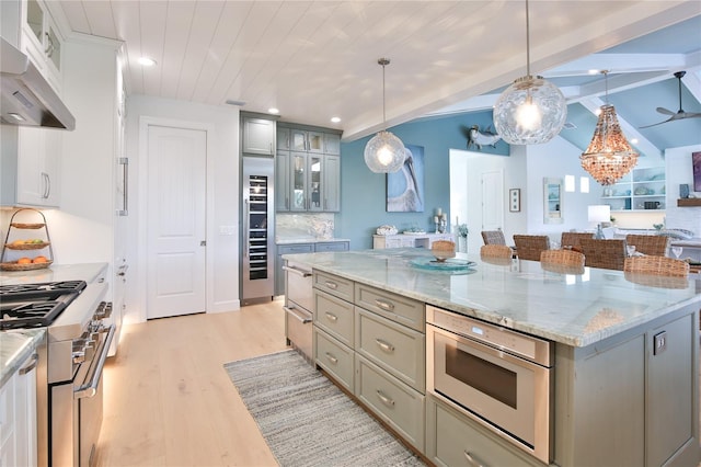 kitchen with a center island, appliances with stainless steel finishes, gray cabinetry, and pendant lighting