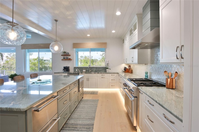 kitchen with white cabinets, light stone counters, and high end stove