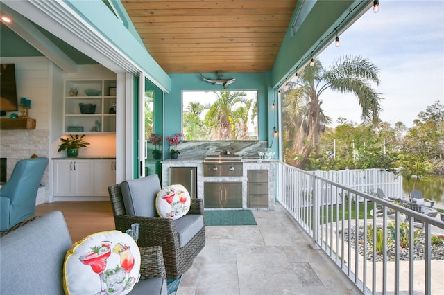 balcony with area for grilling, ceiling fan, and an outdoor kitchen