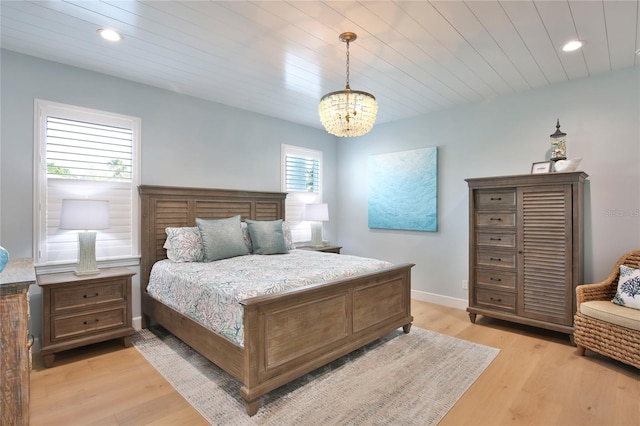 bedroom featuring wood ceiling, a chandelier, and light wood-type flooring