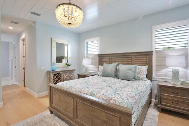 bedroom with an inviting chandelier, wood ceiling, and light wood-type flooring