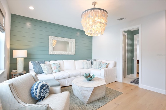 living room featuring a chandelier and light wood-type flooring