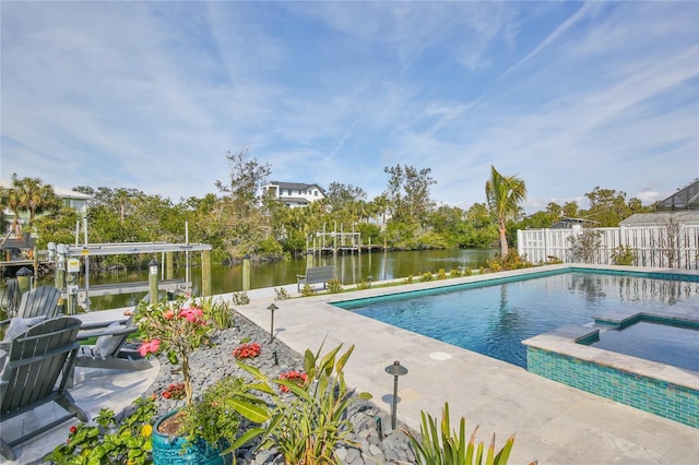 view of swimming pool featuring a patio, a water view, and an in ground hot tub