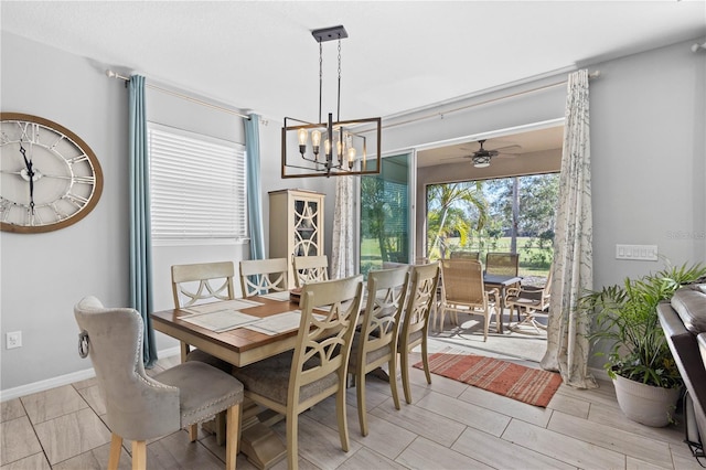 dining space featuring ceiling fan with notable chandelier