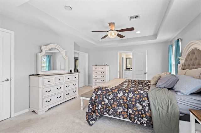 bedroom featuring light carpet, a raised ceiling, and ceiling fan