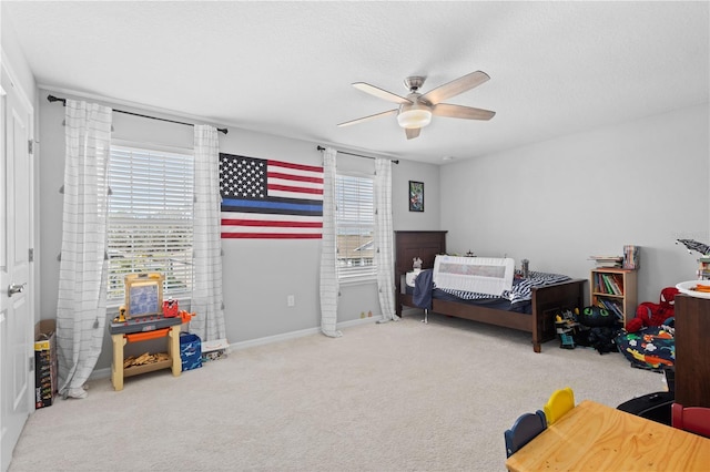 carpeted bedroom featuring multiple windows, ceiling fan, and a textured ceiling