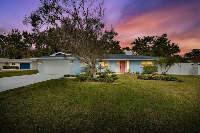 ranch-style home with a garage and a lawn