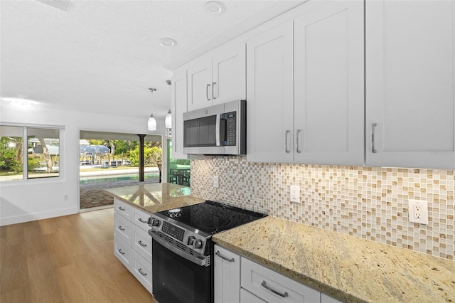 kitchen with white cabinetry, appliances with stainless steel finishes, light hardwood / wood-style floors, and light stone counters