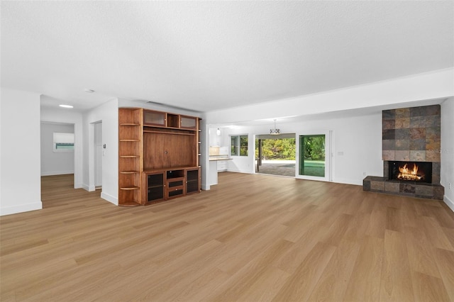 unfurnished living room featuring a textured ceiling, a fireplace, and light hardwood / wood-style flooring