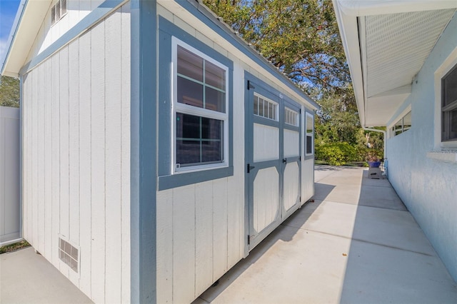 view of property exterior with a shed and a patio area