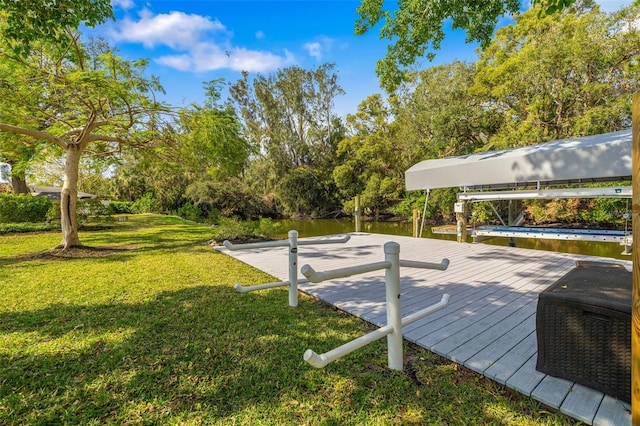 view of dock with a water view and a yard