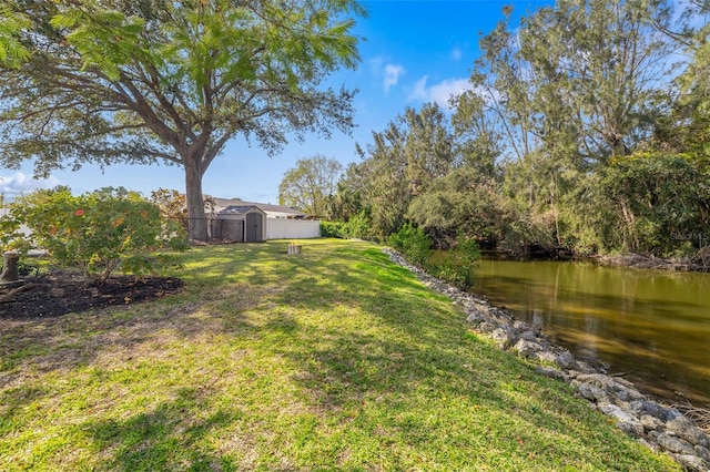 view of yard featuring a water view and a storage unit