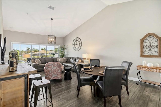 dining space with a notable chandelier, high vaulted ceiling, and dark hardwood / wood-style floors