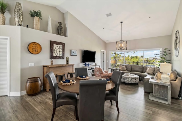 dining space featuring high vaulted ceiling, dark hardwood / wood-style floors, and a chandelier