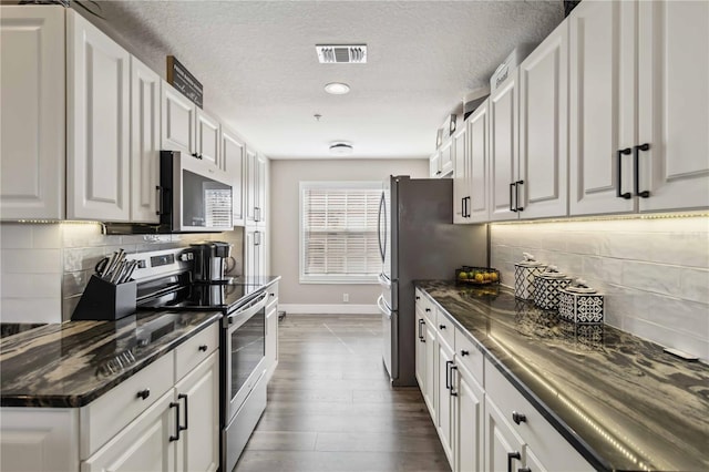 kitchen featuring white cabinetry, backsplash, dark wood-type flooring, and stainless steel appliances