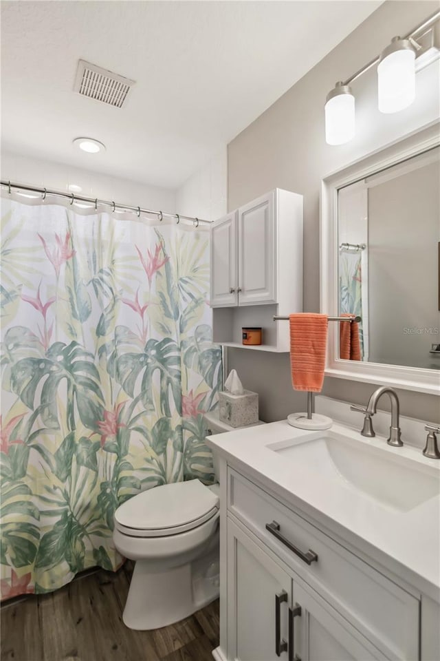 bathroom featuring vanity, hardwood / wood-style flooring, and toilet