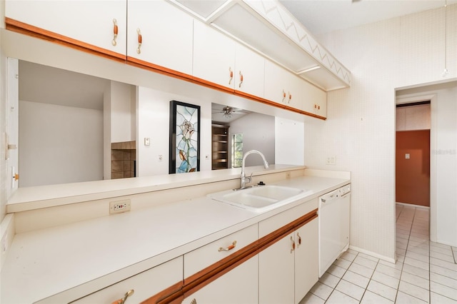 kitchen with light tile patterned flooring, dishwasher, sink, white cabinets, and ceiling fan