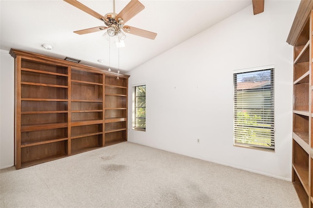 carpeted empty room with ceiling fan and high vaulted ceiling