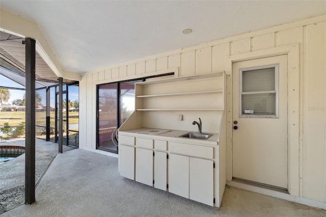 kitchen featuring sink, light carpet, and white cabinets