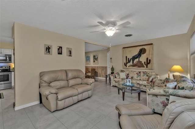 tiled living room with ceiling fan and a textured ceiling