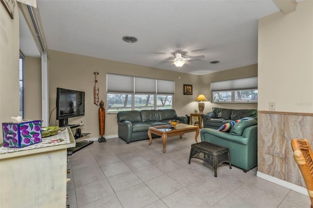 tiled living room featuring a healthy amount of sunlight, a textured ceiling, and ceiling fan