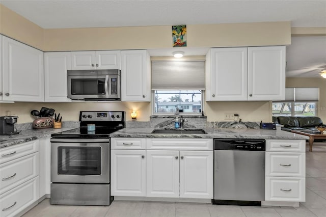 kitchen featuring white cabinetry, appliances with stainless steel finishes, sink, and a wealth of natural light