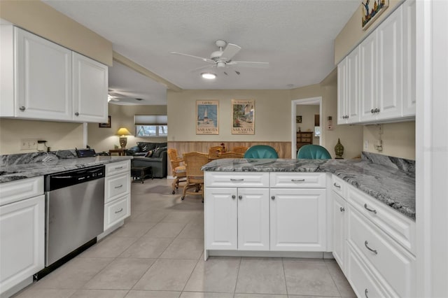 kitchen with kitchen peninsula, white cabinetry, stainless steel dishwasher, light stone counters, and ceiling fan