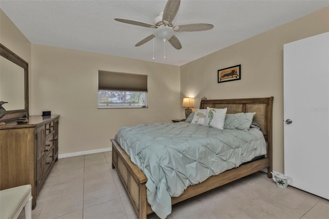 bedroom featuring light tile patterned flooring, ceiling fan, and a textured ceiling