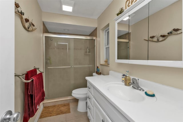 bathroom with vanity, a shower with shower door, tile patterned floors, and toilet