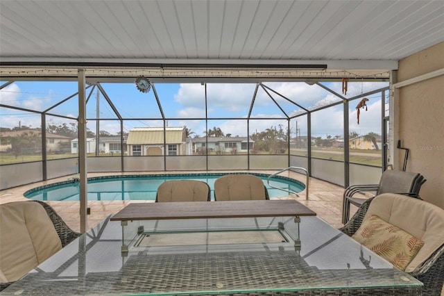 view of pool with a patio area and glass enclosure