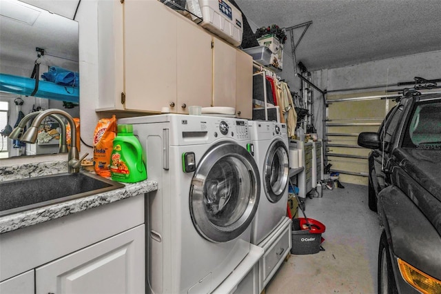 laundry area featuring cabinets, washer and clothes dryer, and sink