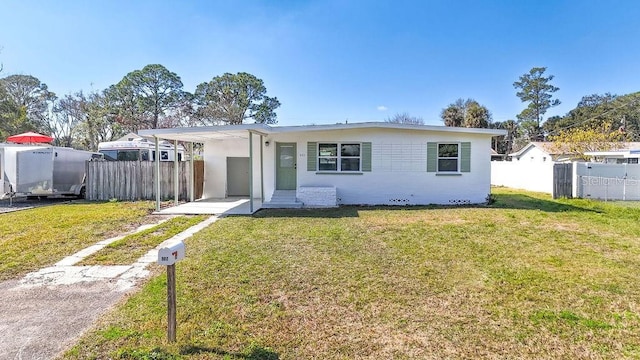 view of front of home with a carport and a front lawn