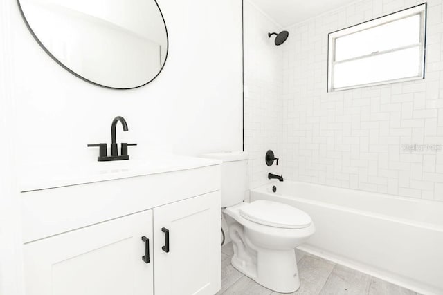 full bathroom with vanity, toilet, and tiled shower / bath combo