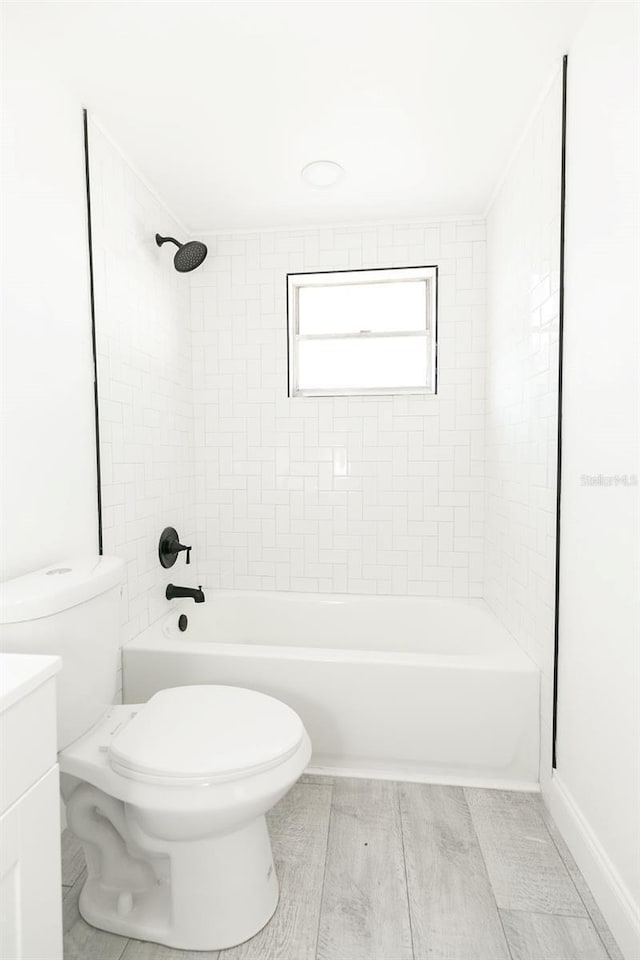 full bathroom with tiled shower / bath, vanity, and toilet