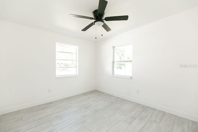 spare room with ceiling fan, plenty of natural light, and light wood-type flooring