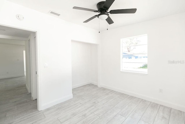 empty room with light hardwood / wood-style flooring and ceiling fan