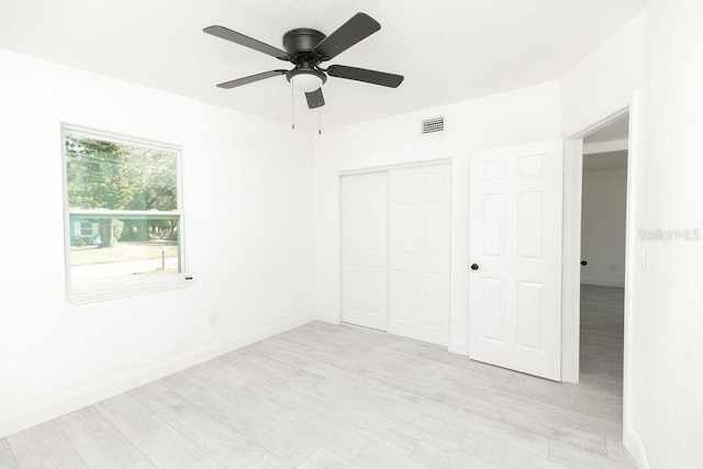 unfurnished bedroom with a closet, ceiling fan, and light wood-type flooring