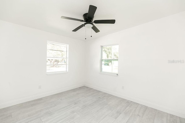 empty room with ceiling fan and light hardwood / wood-style flooring