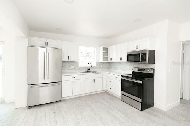 kitchen featuring stainless steel appliances, white cabinetry, sink, and decorative backsplash