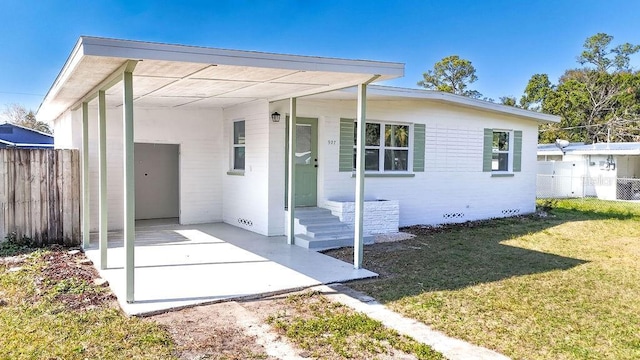 view of front of property with a carport and a front lawn