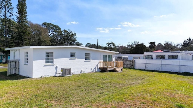 back of house with cooling unit and a lawn