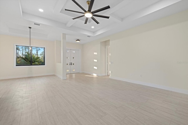 empty room featuring coffered ceiling, beam ceiling, a raised ceiling, and ceiling fan